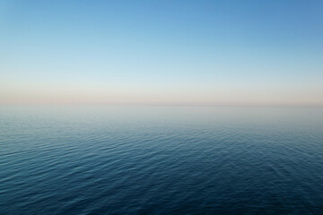 Seemless background of a calm sea with a cloudless sky at sunset with copyspace