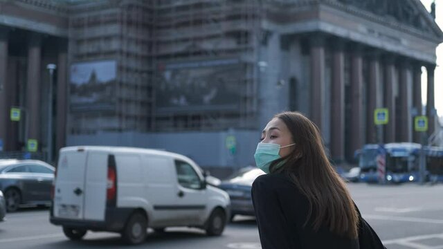 asian woman in a protective mask against the background of the city and isaac's cathedral