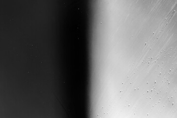 Close-up of a yacht bottom, in black and white. Keel of a white yacht with shadows and water drops on the hull.