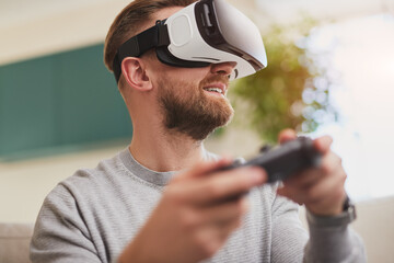 Cheerful man in VR headset enjoying interactive video game