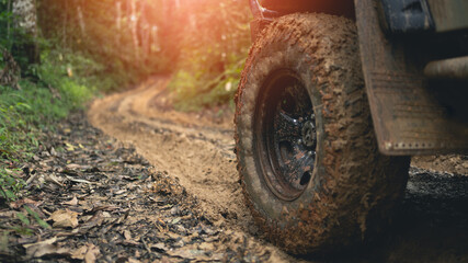 part of off road tires Park on a muddy track in a tropical rainforest. of Nan Province north of...