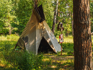 Forest home of the Indians. Wigwam indian teepee. The life of nomadic tribes. The wigwam stands in the forest. A hut of nomadic peoples. A home of Indians. tippi aka in the forest. © alexander_volkov