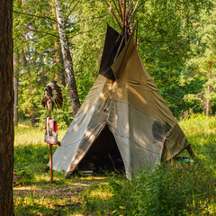 Forest home of the Indians. Wigwam indian teepee. The life of nomadic tribes. The wigwam stands in the forest. A hut of nomadic peoples. A home of Indians. tippi aka in the forest. square © alexander_volkov