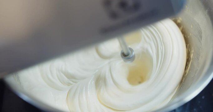 Slow motion automatic flour mixing machine mixing ingredients baking cream cake with flour egg butter and sugar in a bowl, Preparing dessert in the kitchen