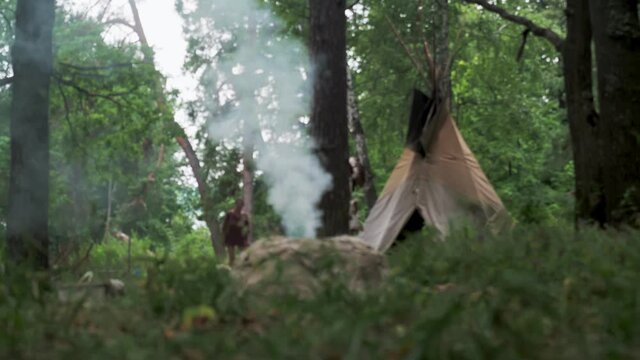 bonfire firing of ceramics of North American Indians in an ancient way. On the background of the tipi, the portable dwelling of the Indians. defocus. 4k