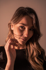 Portrait of a young blonde Caucasian woman on a brown background