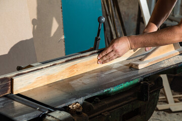 A carpenter works on woodworking the machine tool. Carpenter working on woodworking machines in carpentry shop.