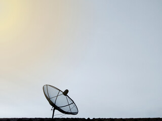 black satellite dish on the roof of the house copy space