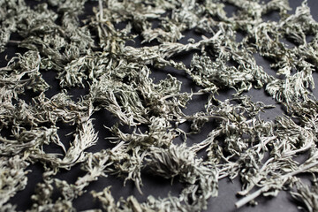 Close-up of dry sagebrush on black table.