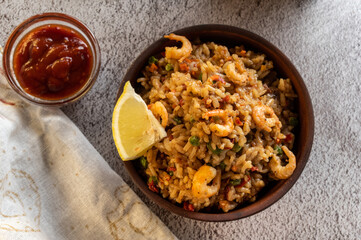 Serve paella with shrimp and lemon. Serving paella with lemon and sauce. Top view. Flat lay,
