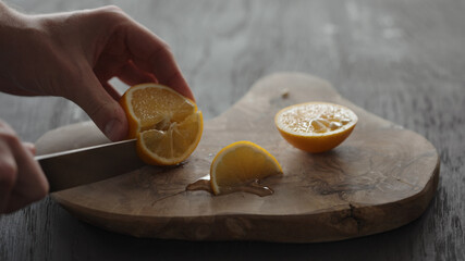 Man cutting sweet lemon on olive wood board