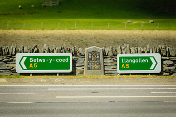Road signs and milestone on the A5 road outside Corwen between Betws y Coed and Llangollen in North East Wales