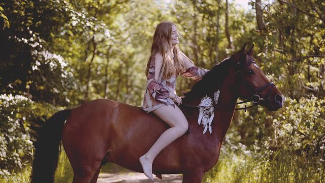 Smiling Girl Sitting Bareback On Horse In Forest