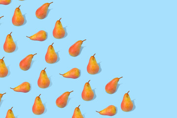 Creative pattern made with fresh pears on  a trendy blue background.