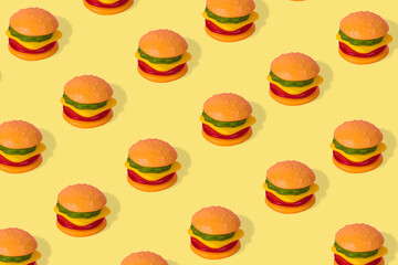 Creative trendy idea fast food pattern-  Hamburger on a yellow background
