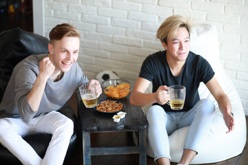 Football fans watch the match and drink beer