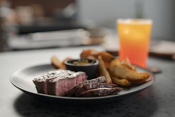 Grilled beef steak with roasted potatoes and pesto sauce