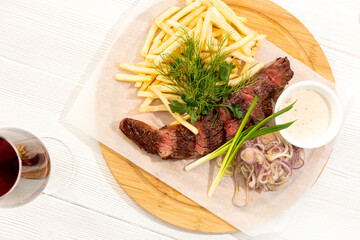 Beef steak with French fries, herbs and red wine