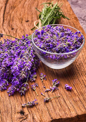 Bunch of lavender and lavender vlowers in glass bowl on wooden board