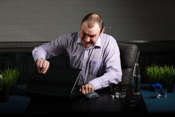 man sitting at table and working on laptop