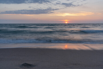 Fototapeta premium Beautifully blurred sea waves at sunset after crashing into the shores of the Baltic Sea