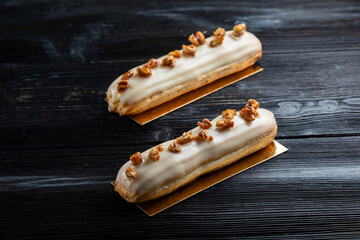 Traditional French dessert. Eclair with white chocolate. Dark background