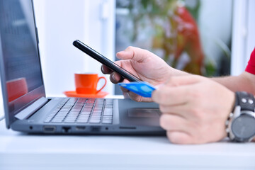 Businessman hands using smarthone and holding credit card.