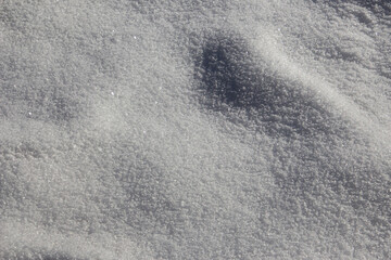 Fresh white snow sparkling in the sun with highlights and shadows for background