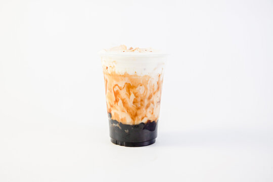 Bubble Milk Tea - Fresh Milk In Plastic Cups With Black Sugar Syrup And Hot Black Pearls. Topped With Cream Cheese On A White Background Taiwanese Drinking Culture