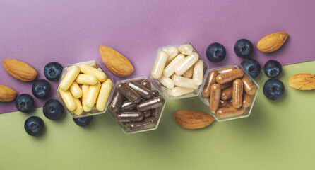 Various capsules with dietary supplements or vitamines in honeycomb form jars
