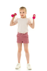 Little girl doing exercises with dumbbells.