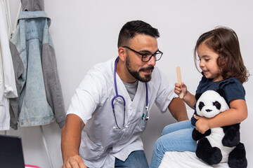 Fototapeta premium Pediatrician examining talking to her little patient