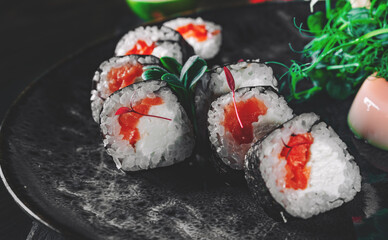 sushi roll in plate on black wooden table background