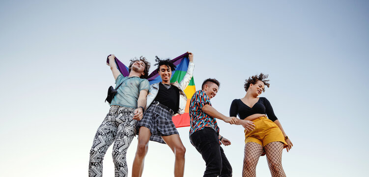Cheerful group of queer individuals dancing at pride