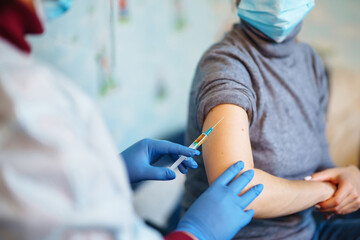 People vaccination concept for immunity health. Covid-19. Doctor makes an injection of flu vaccine to woman at home. Healthcare, coronavirus, prevention and immunize.