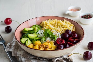 Healthy Salad Bowl with Bulgur, Cherry, Cheese, Cucumber and Walnuts on a light concrete background. Healthy food.