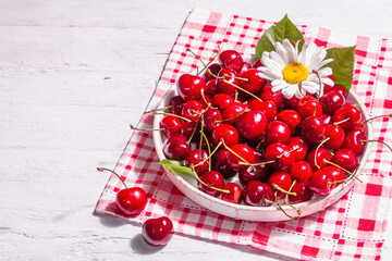 Fresh ripe sweet cherries in a bowl with droplets of water