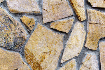 Texture of brown stones laying in pieces. Covering the walls with natural stones