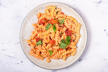 Vegetarian italian girandole pasta with tomato marinara sauce in a plate, close-up, top view
