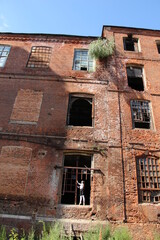 old red brick abandoned factory and ballet dancer in window