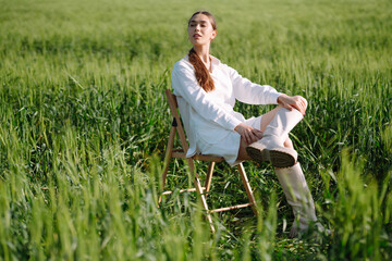 Portrait of beautiful woman in white suit posing in wheat field. Fashion and lifestyle concept. Nature, vacation, relax. Summertime.