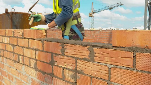 Master at work against the background of a construction crane. Creation of jobs in the construction sector. Concept of construction companies. Work, professionalism. High quality. 4k footage.