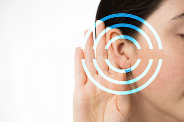 Hearing test. A young woman holds her hand to her ear, close-up. Isolated on a white background....