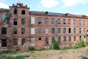 View from window of  old abandoned red brick building on another wall in backyard in sunny summer day