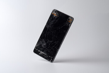 Mobile phone in equilibrium with a very broken screen and the circuitry coming out of the corners