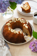 Round bundt cake, homemade pastry cake with coffee cup and flowers on background. Step by step recipe.