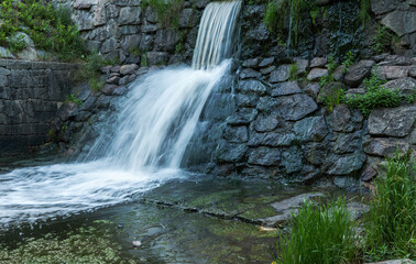 Fototapeta na wymiar Waterfall movement captured in a long exposure in a Swedish summer
