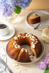 Traditional bundt cake, homemade pastry baked round cake with coffee cup and flowers on background