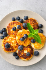Cottage Cheese Pancake with blueberries and mint in a plate on a gray background