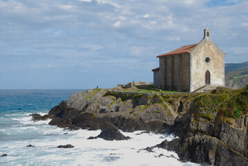 An old stone church on a cliff next to the sea 